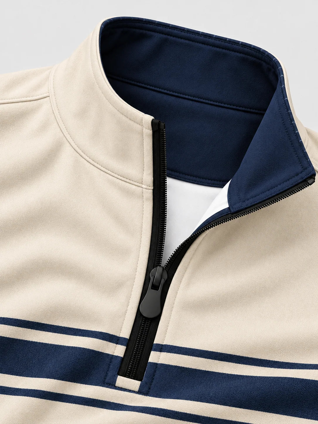 Golfpullover mit Viertelreißverschluss und marineblauem Bruststreifen auf elfenbeinfarbenem Grund, aus Funktionsmaterial
